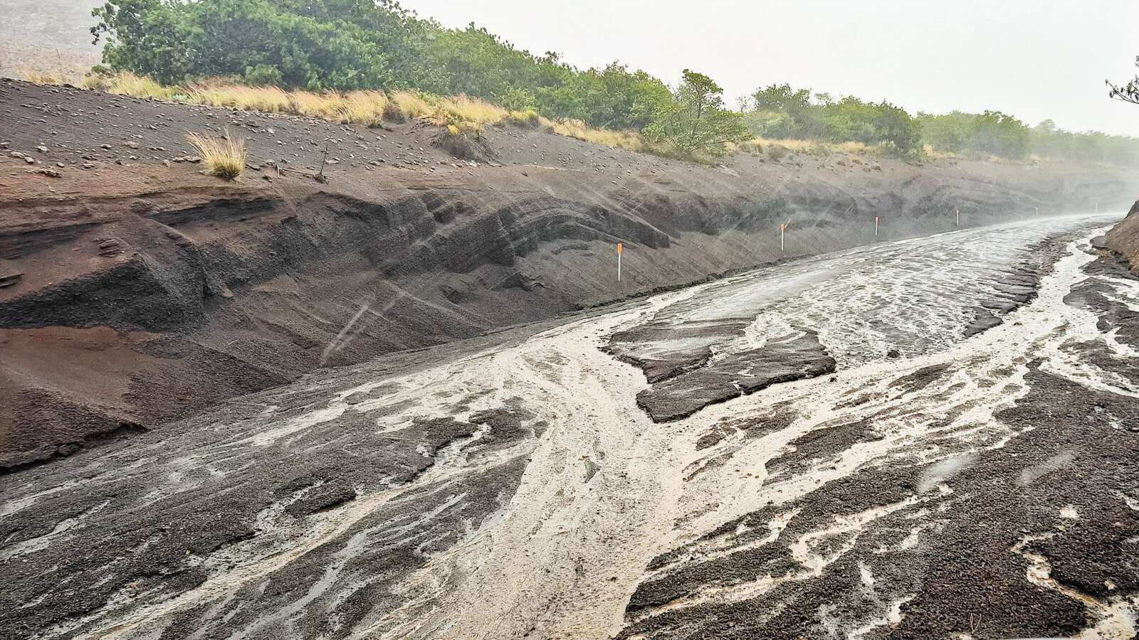 Floodwater and eroded sediment covering the Maunakea access road on Hawaiʻi Island during Hurricane Lala
